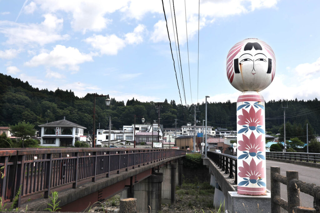 Kokeshi-bashi Bridge with Togatta Onsen in the background. Photo by Mayu Kanamori